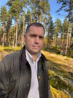 Kuvassa on mies metsän keskellä aurinkoisena päivänä.