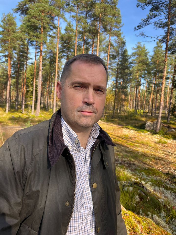 Kuvassa on mies metsän keskellä aurinkoisena päivänä.