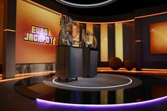 Iso huone, jossa on kaksi lottokonetta ja taustalla suuri "Eurojackpot"-teksti.