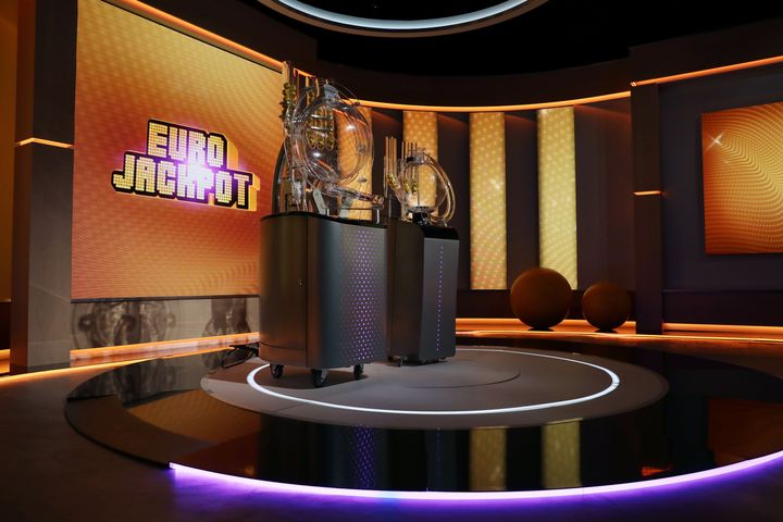 Iso huone, jossa on kaksi lottokonetta ja taustalla suuri "Eurojackpot"-teksti.