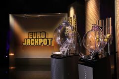 Eurojackpot-studio Helsingissä, sisältäen arvontakoneet ja logon taustalla.