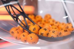 Oransseja arpakuulia läpinäkyvässä koneessa, joihin on painettu numeroita.