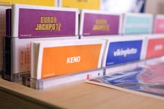 Alt teksti: Keno-pelikuponki kioskin telineessä muiden pelikuponkien rinnalla.