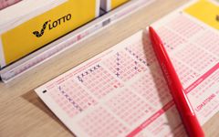 Punainen kynä lepää täytetyn lottokupongin päällä.