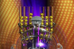 Kuva Eurojackpotin keltaisista numeroiduista palloista arvontatelineessä.