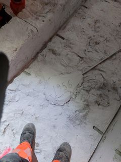 Välipohjien tyhjennyksen jälkeen löytyi alkuperäisestä betonista sen ajan työntekijöiden kengän jälkiä ja mm. tämä merkintä.