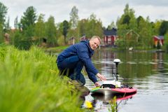 Oulun yliopiston apulaisprofessori Hannu Marttila asettaa mittalaitteen Oulujokeen tutkimuskampanjassa.