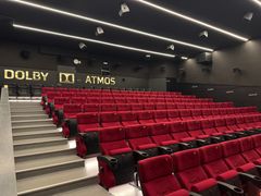 Tyhjä elokuvateatteri, jossa punaiset istuimet ja Dolby Atmos -järjestelmä.