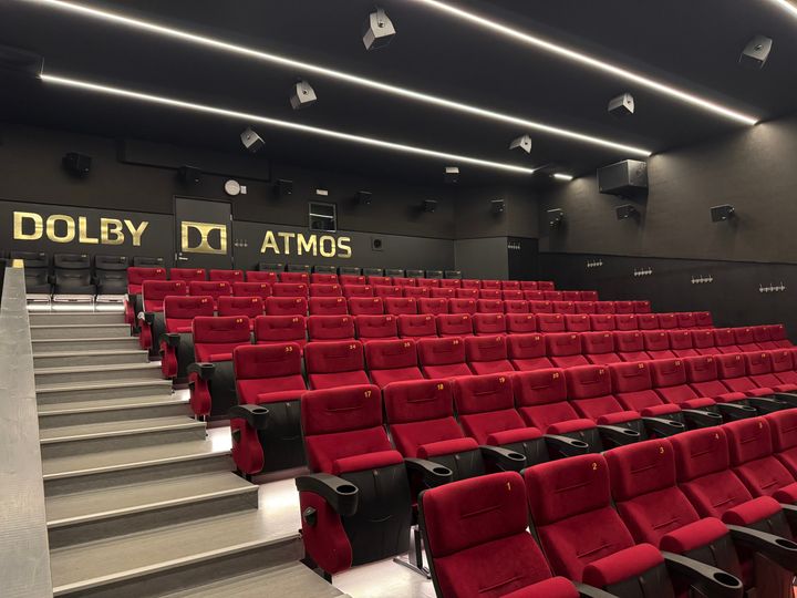 Tyhjä elokuvateatteri, jossa punaiset istuimet ja Dolby Atmos -järjestelmä.