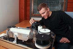 Mies digikuvaamassa vanhoja magneettisia tallenteita sisätiloissa.