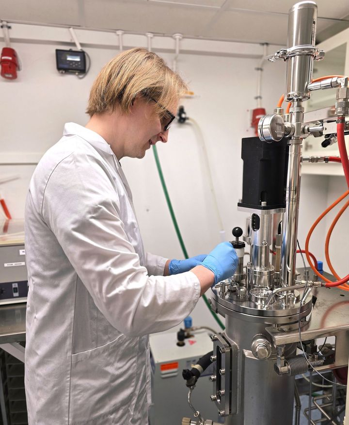 Henkil%F6%20laboratoriotakissa%20ty%F6skentelee%20laboratoriolaitteen%20parissa.