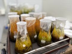 Lasipulloja, joissa on kasvinäytteitä ja päällä suojamateriaalit.