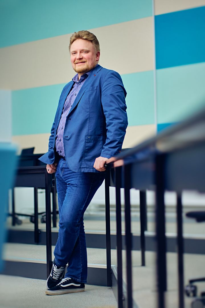 Marko Huttula sinisessä puvussa seisomassa sisätiloissa.