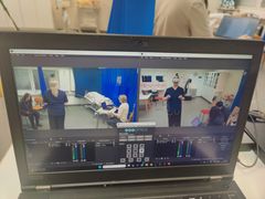 Tietokoneen näytöllä on videokuvia kahdesta huoneesta, joissa on ihmisiä ja laitteita.