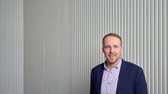 Mies katsoo kameraan puolivartalokuvassa, pikkutakki  yllään.