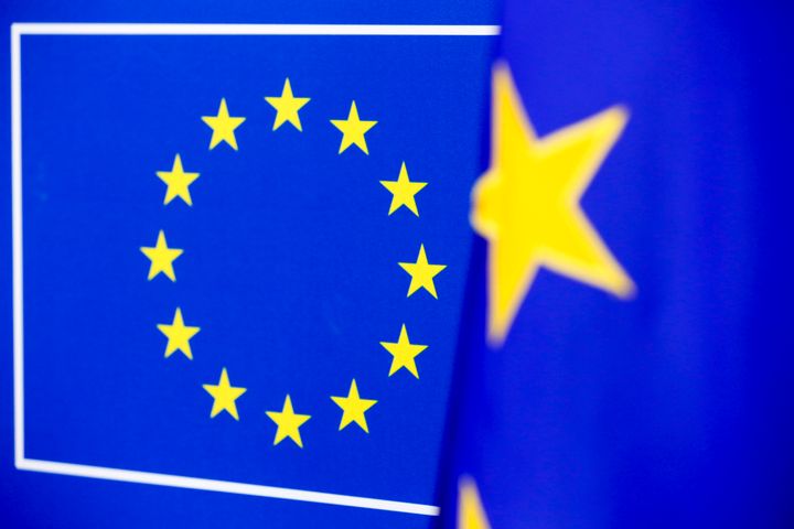 Euroopan unionin lippu, jossa näkyy keltaiset tähdet sinisellä pohjalla, taustalla sumentunut toinen EU-lippu.