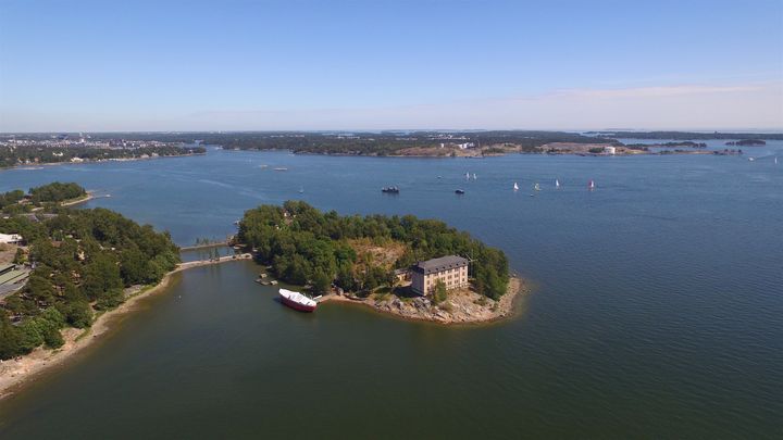 Ilmakuva Hylkysaaresta kesällä vuonna 2018. Kuvan keskellä näkyy luotsiasemarakennus.