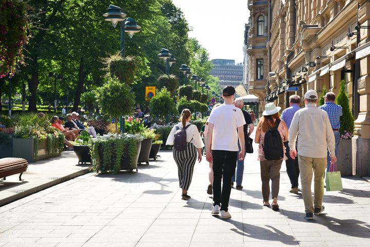 Människor går på gatan på sommaren.