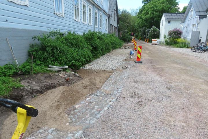 Huomiomerkkejä Suomenlinnan mukulakivikadulla rajaamassa työmaa-aluetta.