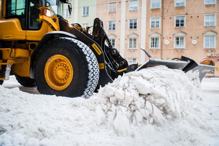 Kauhakuormaaja ajamassa lunta Töölössä.