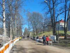 Jalankulkijoita ja pyöräilijöitä Kaisaniemenpuistossa.
