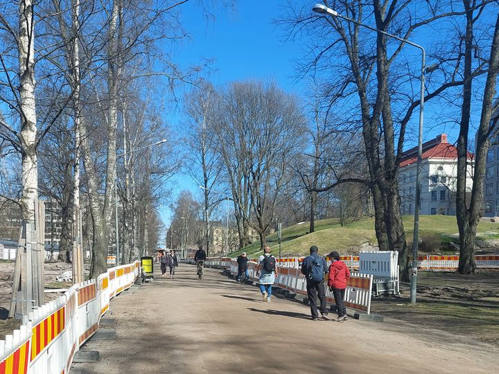 Jalankulkijoita ja pyöräilijöitä Kaisaniemenpuistossa.