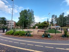 Pienten lasten leikkialuetta ympäröi asfalttinen polkupyöräilyrata tiemerkintöineen.