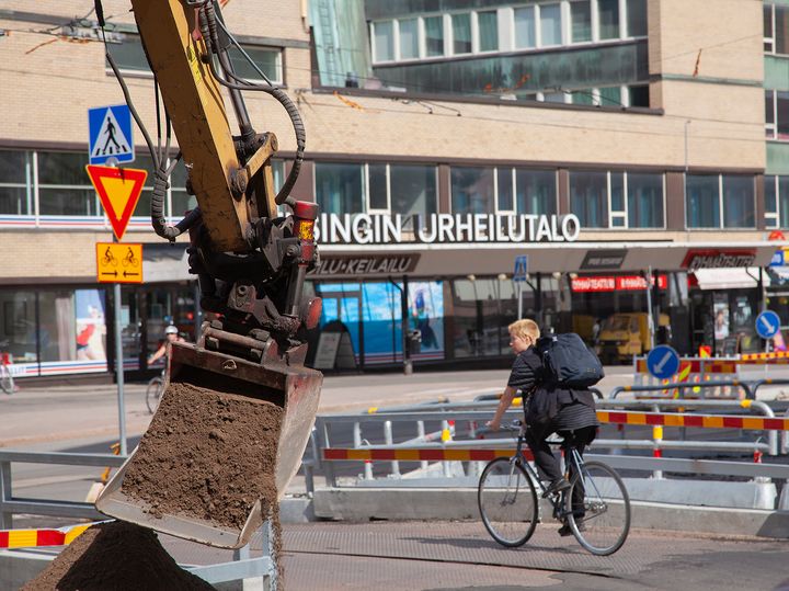 Pyöräilijä ja työmaa.