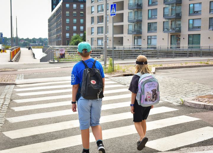 Kaksi lasta ylittämässä suojatietä.
