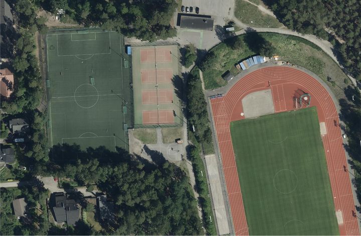 Ilmakuva urheilukentästä, jossa on jalkapallokenttä, tenniskenttiä ja juoksurata.
