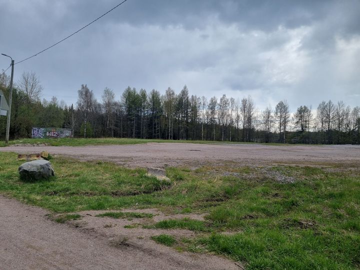 Kuvassa hiekkakenttä, jota reunustaa puurivi.