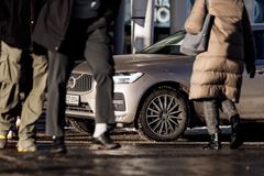 jalankulkijoita ja pysäköity auto.