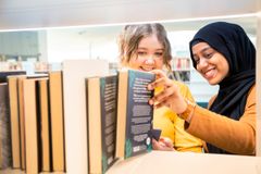 Två unga vid bibliotekets bokhyllor.