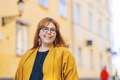 Direktören för kulturcentret Caisa fotograferad framför en gul byggnad.