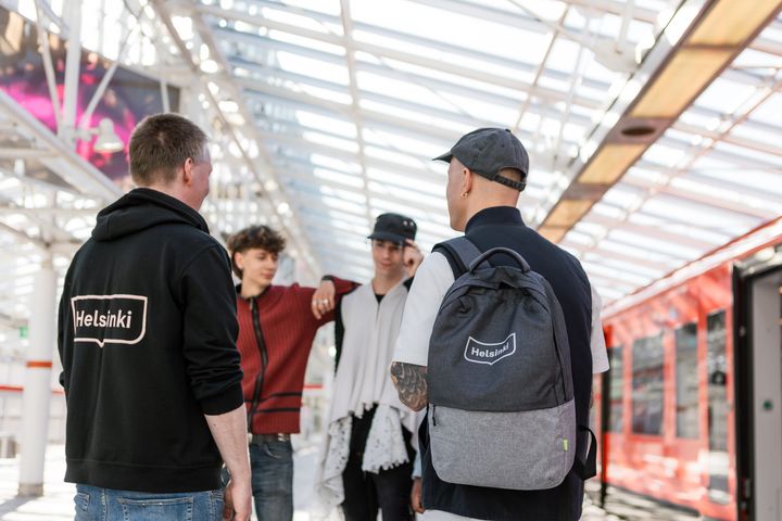 Två ungdomsarbetare talar med unga på en metrostation.