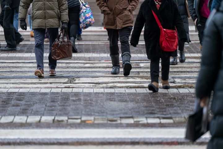 Jalankulkijoita ylittämässä suojatietä.