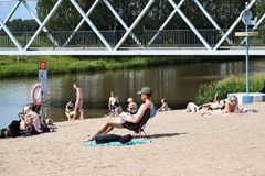 Ihmisiä uimarannalla aurinkoisena päivänä.
