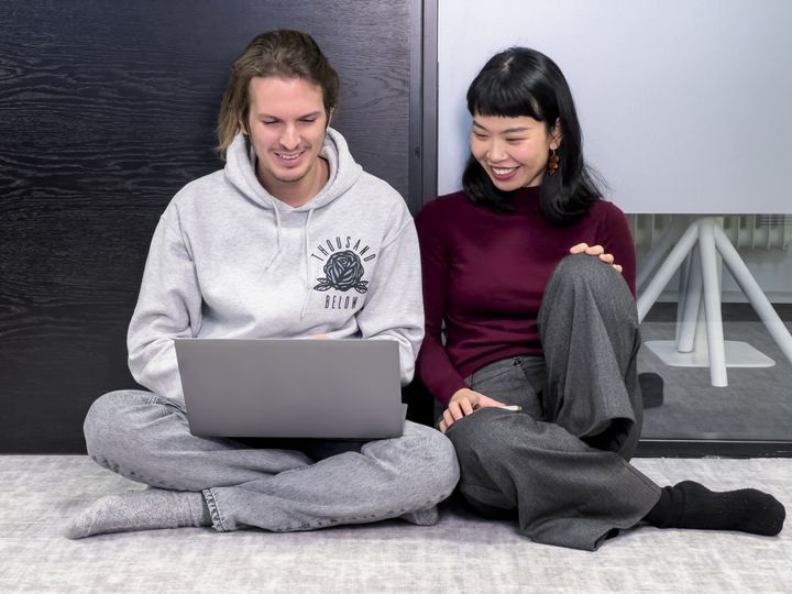 Kaksi henkilöä katsomassa kannettavan tietokoneen näyttöä