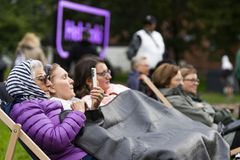Naiset ovat varautuneet lämpimästi pukeutuneina katsomaan ulkoilmaelokuvaa Koffarin Kinofestissä.