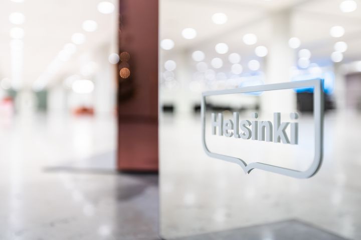 Kuvassa sisäkuva Helsingin kaupungintalolta, etualalla Helsinki-logo.