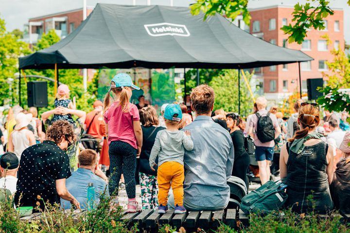 Ihmiset osallistuvat aurinkoisena päivänä ulkoilmatapahtumaan.