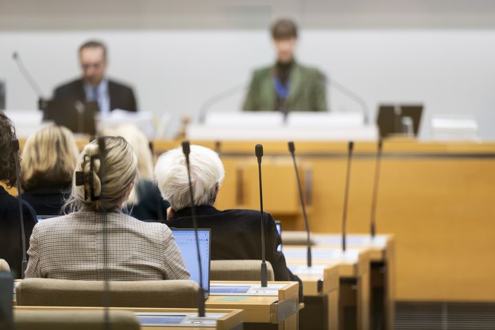 Ihmisiä kaupunginvaltuuston istuntosalissa.