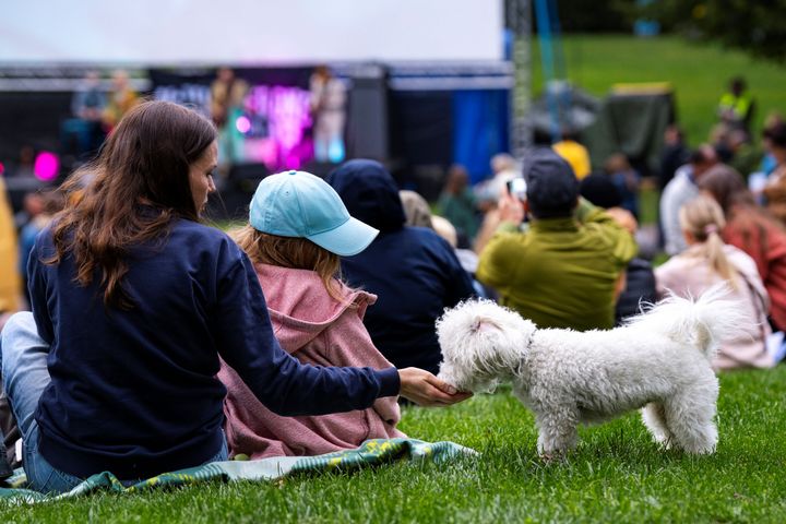 Nainen, lapsi ja koira nauttivat ulkoilmatapahtuman tunnelmasta.