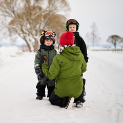 Kaksi lasta ja aikuinen talvisessa maisemassa