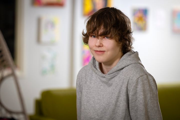 Nuori poika harmaassa hupparissa katsoo kameraan.