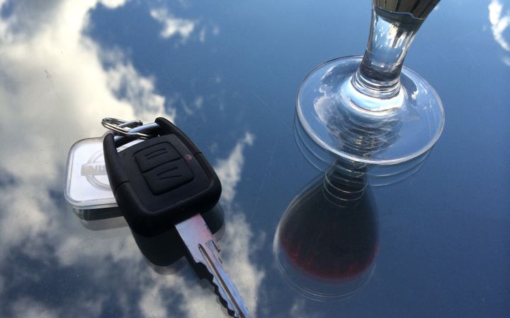 auton avaimet ja jalallinen alkoholilasi