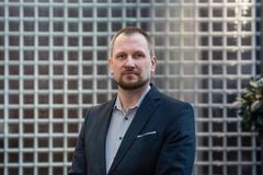 Onnettomuustietoinstituutin teknologiapäällikkö Tapio Koisaari katsoo kameraan puku päällä.