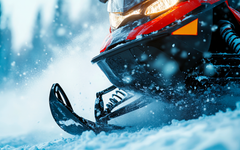 Moottorikelkka liikkeessä lumisessa maastossa.