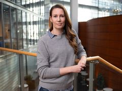 Asiantuntija katsoo kameraan toimistoympäristössä.