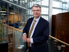 Asiantuntija katsoo kameraan toimistoympäristössä.